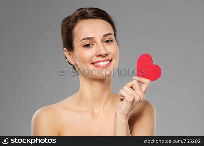 valentines day, beauty and love concept - happy smiling young woman with pink heart shape over grey background. beautiful woman with pink heart shape