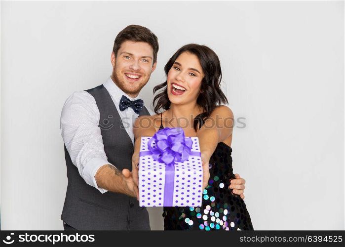 valentines day, birthday, anniversary and holidays concept - happy couple with gift box at party. happy couple with gift box at birthday party