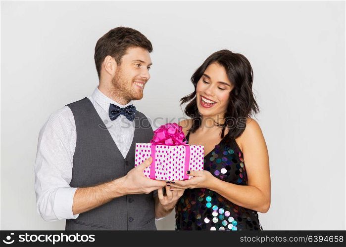 valentines day, birthday, anniversary and holidays concept - happy couple with gift box at party. happy couple with gift box at birthday party