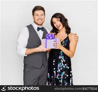 valentines day, birthday, anniversary and holidays concept - happy couple with gift box at party. happy couple with gift box at birthday party. happy couple with gift box at birthday party