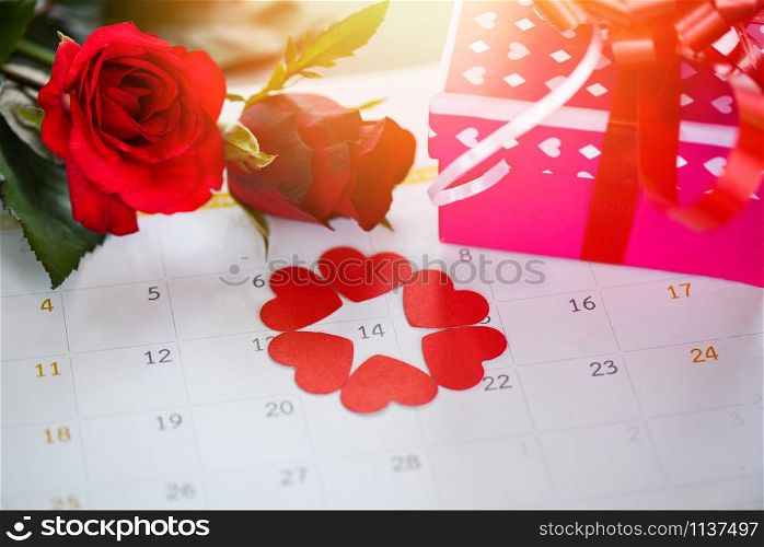 Valentines day calendar love time concept / Calendar page with red heart on February 14 of Saint Valentine&rsquo;s day pink gift box and red roses flower