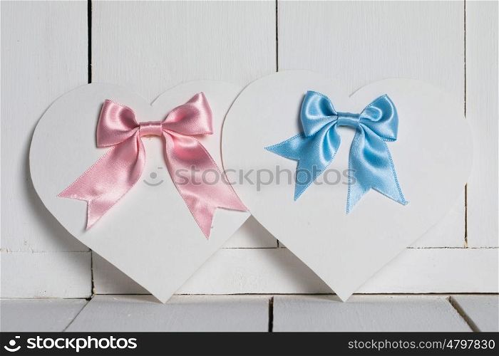 Valentines Day cards. Valentines Day heart shaped paper cards with satin ribbon bows on white wooden background