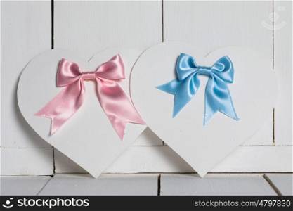 Valentines Day cards. Valentines Day heart shaped paper cards with satin ribbon bows on white wooden background