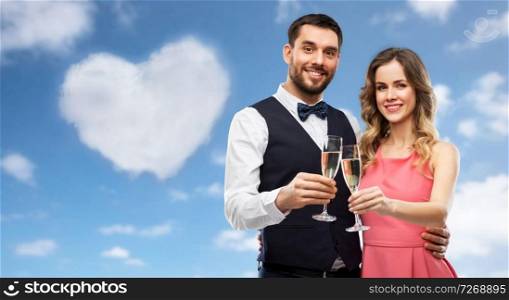 valentines day, celebration and people concept - happy couple with ch&agne glasses toasting over blue sky and heart shaped cloud background. happy couple with ch&agne glasses toasting