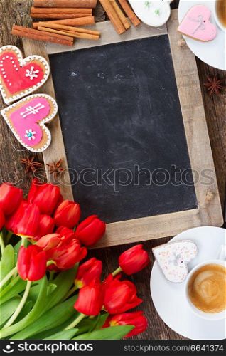 Valentines day coffee with tulips bouquet and gift box, copy space on blackboard. Valentines day coffee