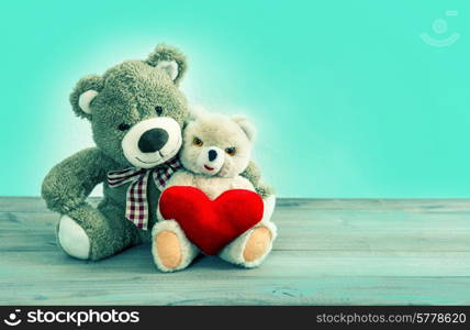 Valentines Day concept. Teddy Bears couple with red heart. Hipster style toned picture with mint green background