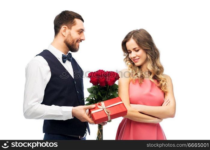 valentines day, couple, relationships and people concept - happy man giving woman flowers and present. happy man giving woman flowers and present
