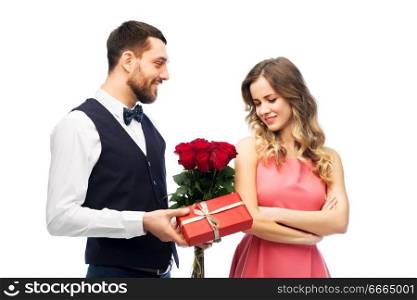 valentines day, couple, relationships and people concept - happy man giving woman flowers and present. happy man giving woman flowers and present