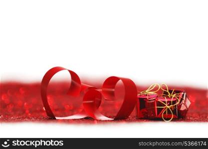 Valentines day decorative hearts and gifts on red glitter background