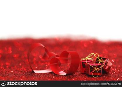 Valentines day decorative hearts and gifts on red glitter background