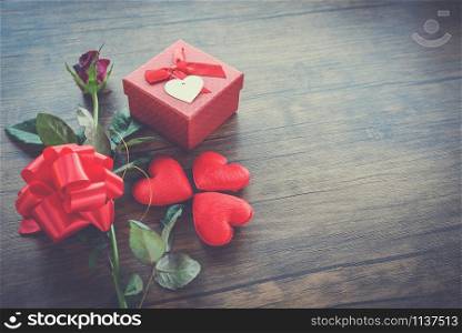 Valentines day gift box red on wood background / Red Heart Valentines day red rose flower and present box ribbon bow on old wooden - Love concept top view copy space