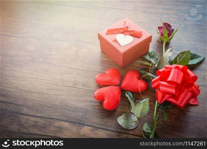 Valentines day gift box red on wood background / Romantic red Heart Valentines day red rose flower and present box ribbon bow on old wooden - Love concept top view copy space
