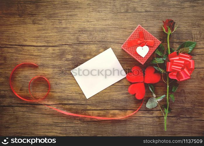 Valentines day gift box red on wood background / Valentines day card rose flower and gift box ribbon bow - Envelope love mail Valentine Letter Card with Red Heart Love romantic concept