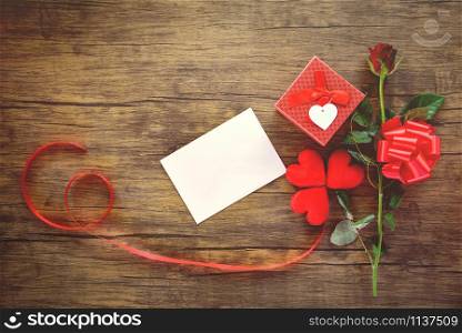 Valentines day gift box red on wood background / Valentines day card rose flower and gift box ribbon bow - Envelope love mail Valentine Letter Card with Red Heart Love romantic concept