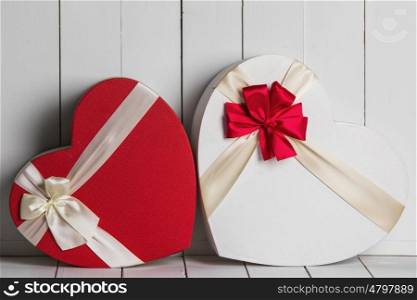 Valentines Day gift boxes. Heart shaped Valentines Day gift boxes on white wooden background