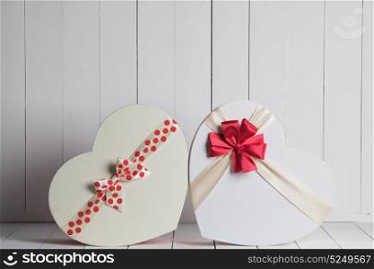 Valentines Day gift boxes. Heart shaped Valentines Day gift boxes on white wooden background
