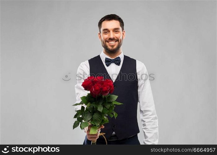 valentines day, greeting people concept - happy man in party clothes with bunch of red roses over grey background. happy man with bunch of red roses
