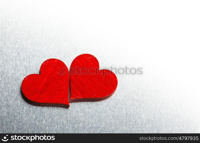 Valentines day hearts on metal. Two wooden red painted Valentine day hearts on metal background