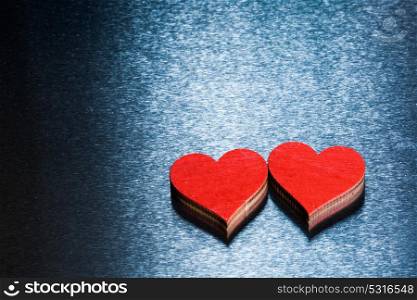 Valentines day hearts on metal. Two wooden red painted Valentine day hearts on metal background