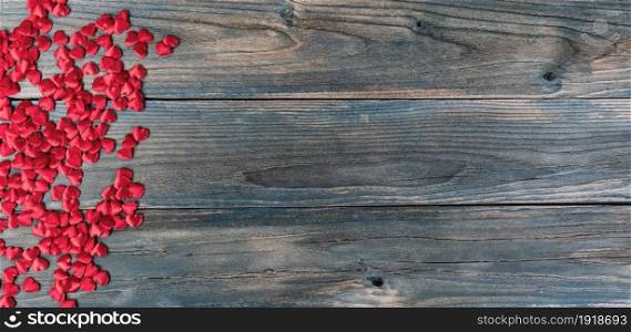 Valentines day holiday background with border of little heart shapes on faded blue wooden planks
