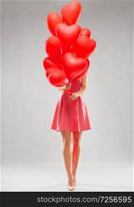 valentines day, love and people concept - young woman with bunch of red heart shaped balloons. young woman with red heart shaped balloons
