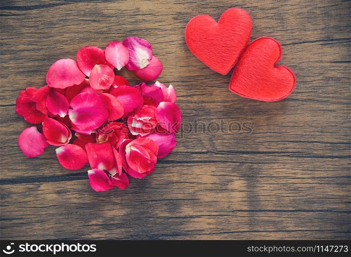Valentines day love heart concept / Pile of roses petals with red heart decorated on wooden table rustic background