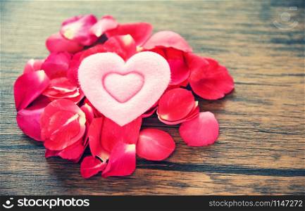 Valentines day love heart romantic concept / Pile of roses petals with pink heart decorated on wooden table rustic background