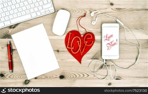 Valentines Day Office Desk with Red Heart and Mobile Phone. Sample text Love You!