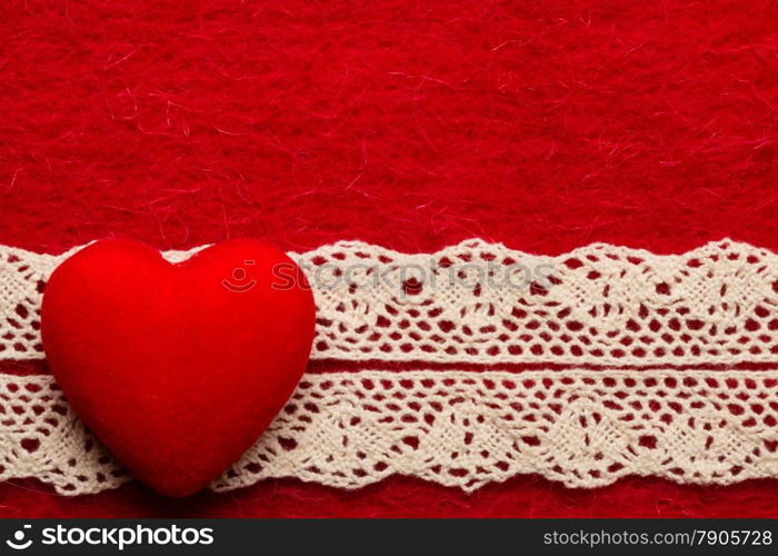 Valentines day or wedding concept. Big decorative heart lace ribbon on abstract red cloth background. Border frame.
