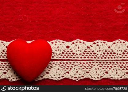 Valentines day or wedding concept. Big decorative heart lace ribbon on abstract red cloth background. Border frame.