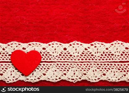 Valentines day or wedding concept. Wooden decorative heart lace ribbon on abstract red cloth background. Border frame.