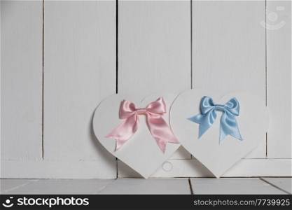 Valentines Day ornate heart shaped cards with pink and blue ribbon bows on white wooden background with copy space for text. Valentines Day ornate cards