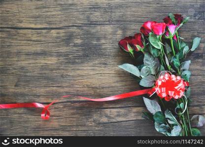 Valentines day red rose flower on wooden background / Red heart with roses and red ribbon on top view copy space