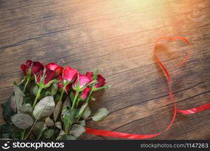 Valentines day red rose flower on wooden background / Red heart with roses and red ribbon heart on top view copy space