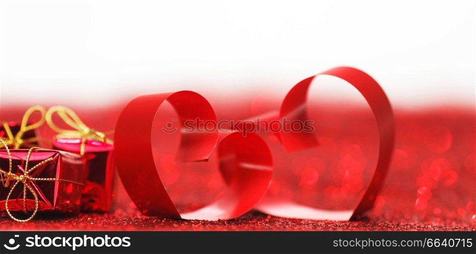 Valentines day ribbon hearts and gifts on decorative glitters, isolated on white