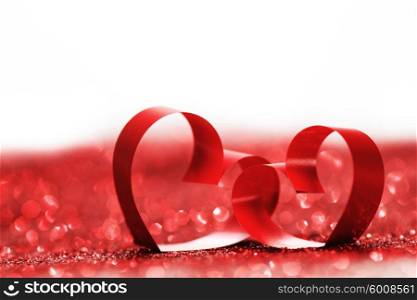 Valentines day ribbon hearts on decorative glitters, isolated on white