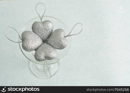 Valentines day. Silver hearts in a glass . Top view.