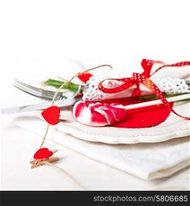 Valentines day table setting with plate, knife, fork, red ribbon and hearts