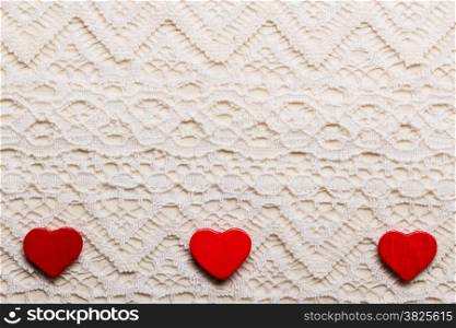 Valentines day wedding, invitation or greeting card. Red decorative hearts love symbol on white cloth lace background