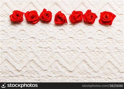 Valentines day wedding, invitation or greeting card. Red decorative satin rose flowers on white cloth lace background