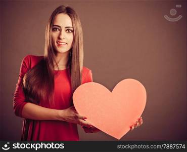 Valentines Day. Woman holding heart sign with copy space studio shot. Vintage retro photo.