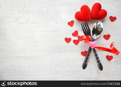 Valentines dinner romantic love food and love cooking concept - Romantic table setting decorated with fork spoon and red heart on white wooden texture background top view copy space