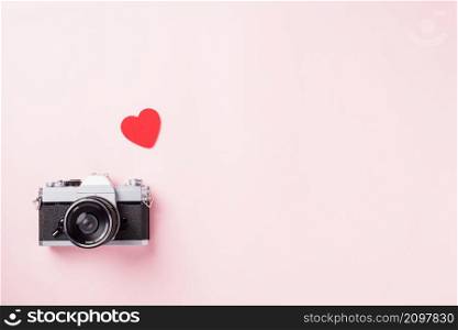 Valentines&rsquo; day background. Vintage retro camera and red hearts composition greeting card love Valentines day I love photography concept on pink background with copy space. Top View from above
