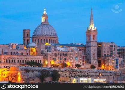 Valletta Skyline from Sliema at night, Malta. Valletta Skyline from Sliema with church of Our Lady of Mount Carmel and St. Paul&rsquo;s Anglican Pro-Cathedral during evening blue hour, Valletta, Capital city of Malta