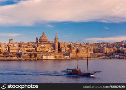 Valletta Skyline from Sliema at sunset, Malta. Valletta Skyline with ship at beautiful sunset from Sliema with churches of Our Lady of Mount Carmel and St. Paul&rsquo;s Anglican Pro-Cathedral, Valletta, Capital city of Malta