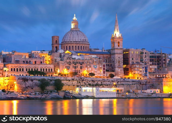 Valletta Skyline from Sliema with church of Our Lady of Mount Carmel and St. Paul's Anglican Pro-Cathedral during evening blue hour, Valletta, Capital city of Malta. Valletta Skyline from Sliema at night, Malta