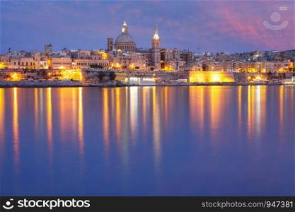 Valletta Skyline from Sliema with church of Our Lady of Mount Carmel and St. Paul's Anglican Pro-Cathedral during evening blue hour, Valletta, Capital city of Malta. Valletta Skyline from Sliema at night, Malta