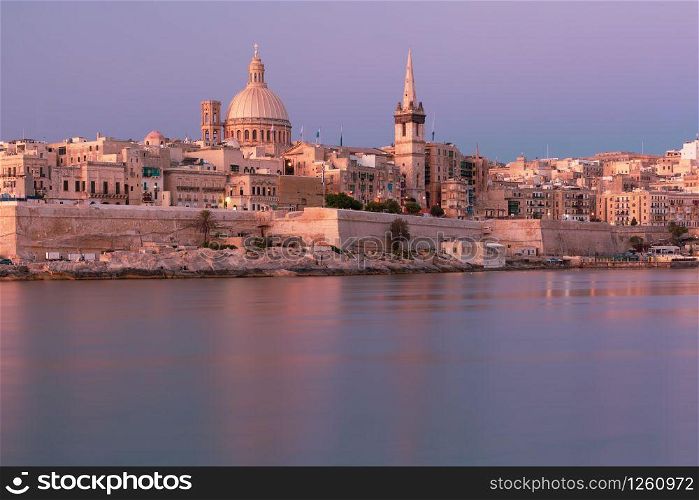 Valletta with Our Lady of Mount Carmel church and St. Paul&rsquo;s Anglican Pro-Cathedral at sunrise as seen from Sliema, Valletta, Malta. Valletta Skyline from Sliema at sunset, Malta