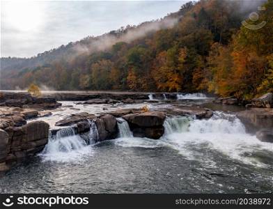 Valley Falls State Park near Fairmont in West Virginia on a colorful misty autumn day with fall colors on the trees. Cascades of the Valley Falls on a misty autumn day