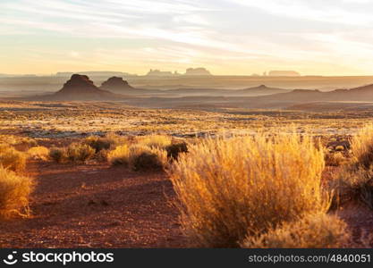 Valley of the Gods rock formation with Monument Valley at sunrise